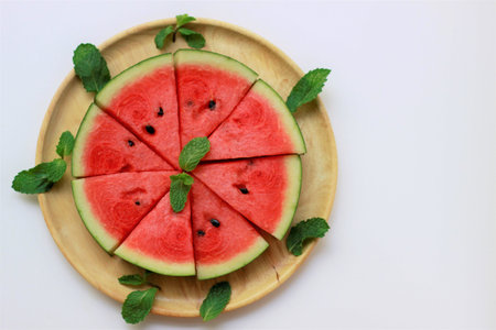 Sliced juicy watermelon pizza on a wooden plate, summer fruits, summer dessert, top view