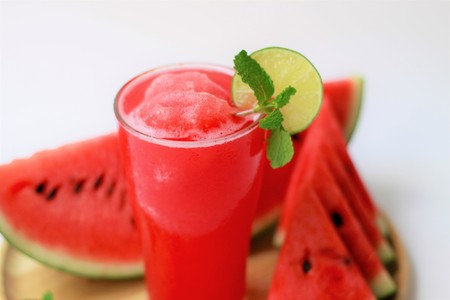 Watermelon smoothie in glass with lime on a wooden plate-white backgroundの写真素材