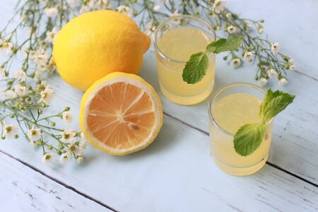 Glasses of fresh  lemon juice with mint leaves and lemons on wooden bakground, Summer cocktails and drinksの写真素材