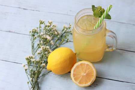 Refreshing summer drinks with lemon juice and ice cubes on wooden backgroundの写真素材