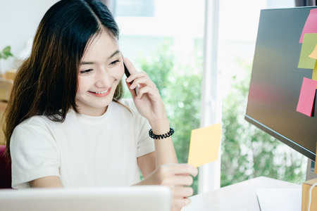 Young asian girl is freelancer with her private business at home office, working with laptop, coffee, online marketing, Customer order and packaging or packing.の写真素材
