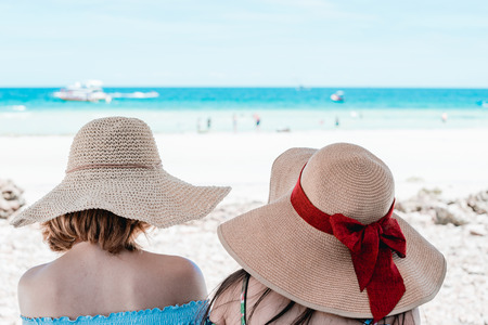 Young Asian woman wearing Hawaiian with hat and sunglasses is happy when they go to the beach for a holiday.の写真素材