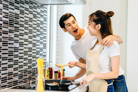 Asian teen couple are helping to make dinner. And bakery together happily. On Valentine's Day in their home.の写真素材