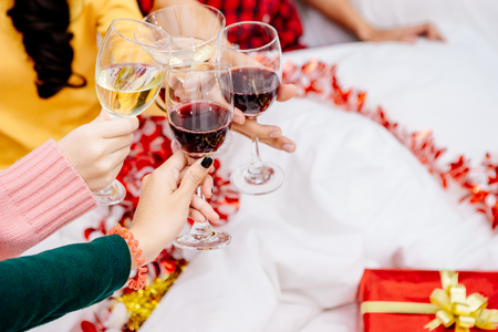 Groups of friends are Asian men and women decorated the Christmas tree. To celebrate the Christmas season. They drink wine and champagne to enjoy together happily.の写真素材