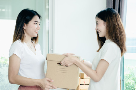 Young asian girl is freelancer with her private business at home office, working with laptop, coffee, online marketing, Customer order and packaging or packing.の写真素材