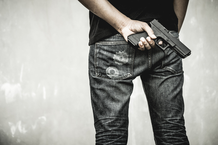 A man holding a gun in hand, the ship ready to shoot the man pointed a gun at us. A man holding a gun was robbed.の写真素材