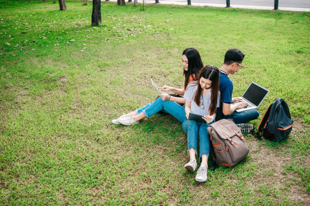 A group of young or teen Asian student in university smiling and reading the book and look at the...