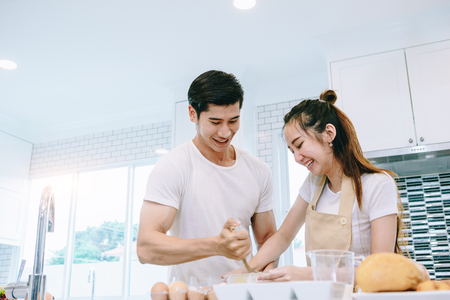 Asian teen couple are helping to make dinner. And bakery together happily. On Valentine's Day in their home.の写真素材