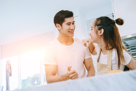 Asian teen couple are helping to make dinner. And bakery together happily. On Valentine's Day in their home.の写真素材