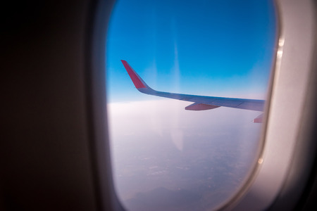 The left wing of one of the aircraft while floating above the skies. Photo from the passenger window on the plane.の写真素材