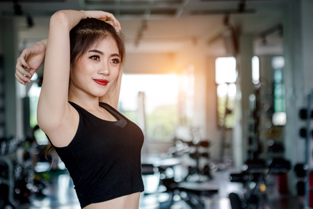 Asian woman exercising in the gym, Young woman workout in fitness for her healthy and office girl lifestyle.の写真素材