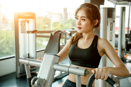 Asian woman exercising in the gym, Young woman workout in fitness for her healthy and office girl lifestyle.の写真素材