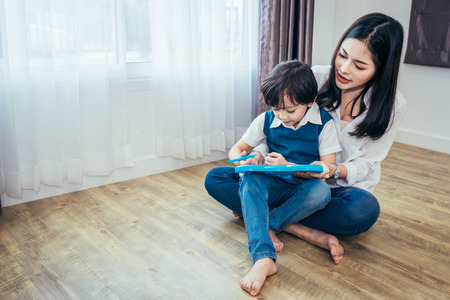 Mom was teaching her son drawing with crayons.の写真素材