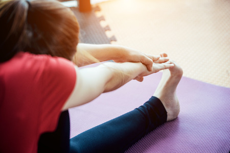 Asian girl playing with a yoga school at yoga class in early morning. Lifestyle and healty concept.の写真素材