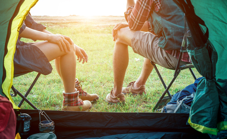 Asian couple is camping and walking along the road into the forest on weekend, Travel relaxing and adventure concept.の写真素材