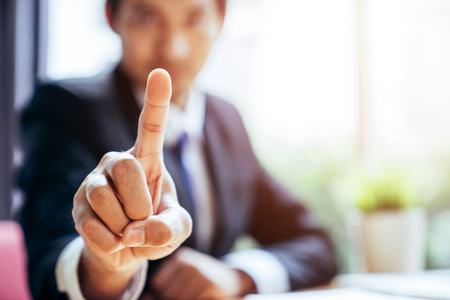 Close up a point finger at right hand of an Asian business man, Business concept.の写真素材