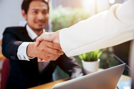Business man and office concenpt. business man is hand shaking with business woman.の写真素材