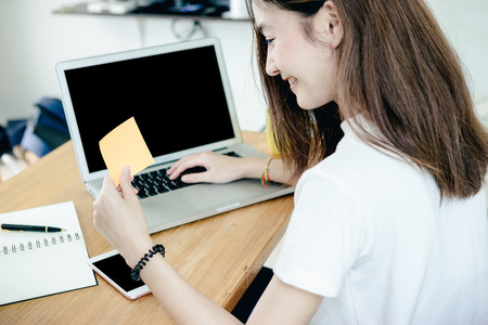 Young asian girl is freelancer with her private business at home office, working with laptop, coffee, online marketing, Customer order and packaging or packing.の写真素材