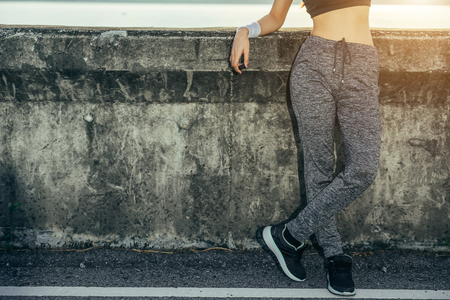 Asian woman is workout and running at the morning, she is warm up her body and drinking water. Healty and sport lifestyle concept.の写真素材