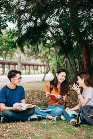 A group of young or teen Asian student in university smiling and reading the book and look at the...