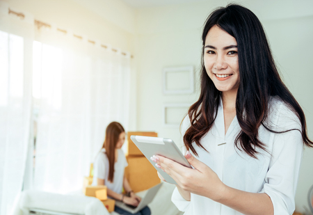 Young asian girl is freelancer with her private business at home office, working with laptop, coffee, online marketing. Young woman startup her SME business.の写真素材