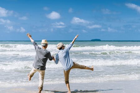 Asian senior couple or elderly people walking and siting at the beach on their weekend vacation holiday. Retirement vaction concept.の写真素材