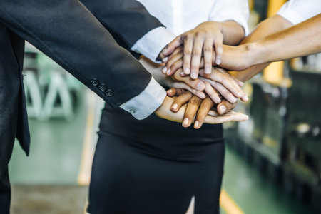 Three office people touching their hands, cooperation concept.