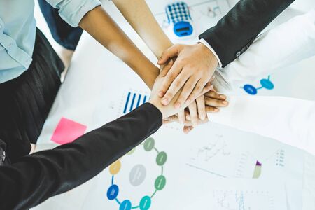 Asian business people showing their hands together. Group of office people joining hands and representing concept of friendship, teamwork and partnership concept.の写真素材