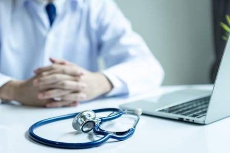 Asian doctor man wearing stethoscope white coat in his office hospital building.