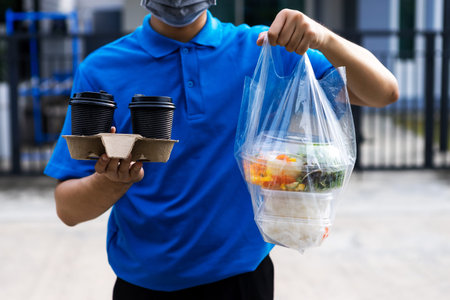 Asian delivery man delivering food, fruit, juice and vegetable to customer home - online grocery shopping service concept