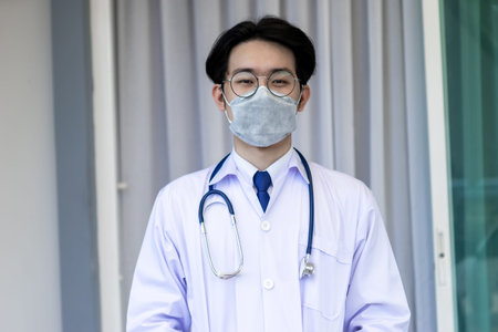 Portrait of Asian doctor man wearing stethoscope white coat standing in modern hospital.