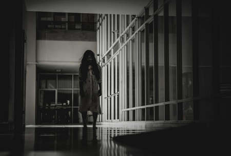 Woman in ghost or zombie on halloween festival at dark place, holding knife and wants to stab you. Horror or halloween festival concept.の写真素材