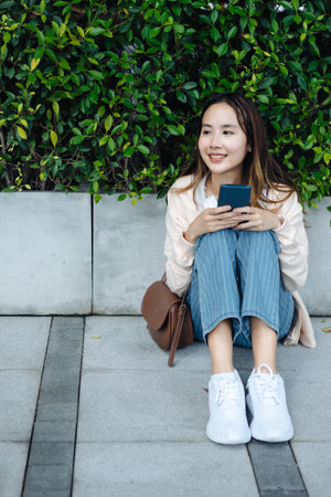 Beautiful Asian woman listening favourite music on headphones from mobile phone, Happiness relaxation summer in park with music riding bicycle in green park.の写真素材