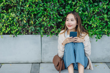 Beautiful Asian woman listening favourite music on headphones from mobile phone, Happiness relaxation summer in park with music riding bicycle in green park.の写真素材