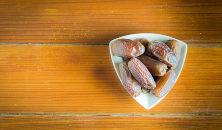 dried dates on wooden background with space for textの写真素材