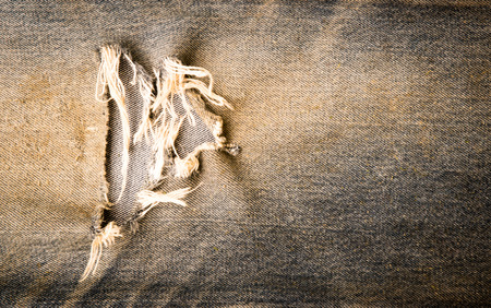 Torn old black denim texture backgroundの写真素材