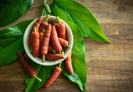 Fresh long pepper or Indian long pepper on wood background, spices and herbsの写真素材