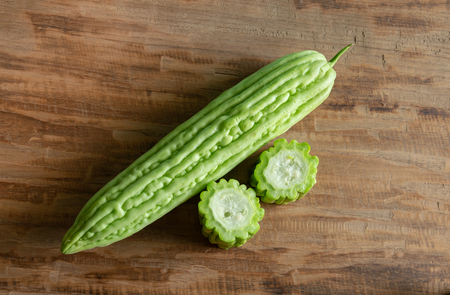 Fresh bitter gourd or bitter melon on wood backgroundの写真素材