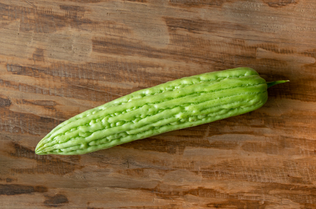 Fresh bitter gourd or bitter melon on wood backgroundの写真素材