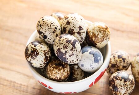 Fresh quail egg in bowl on a wooden backgroundの写真素材