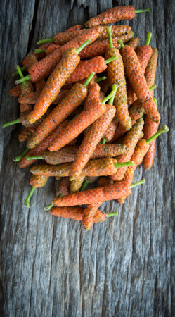 Long pepper on wood background with space for textの写真素材