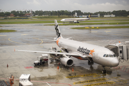 SINGAPORE, MARCH 28,2017: Jetstar aircraft in Changi International Airport during unloading baggage.のeditorial素材