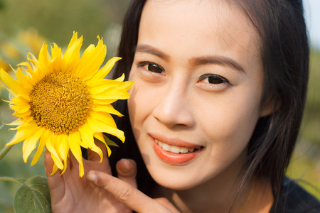 Young beautiful woman in a sunflower field.の写真素材