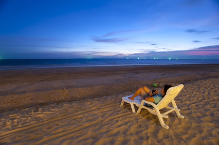 Woman on the  beach with chairの写真素材
