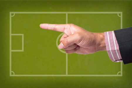 Hand Point a soccer game strategy on a blackboardの写真素材