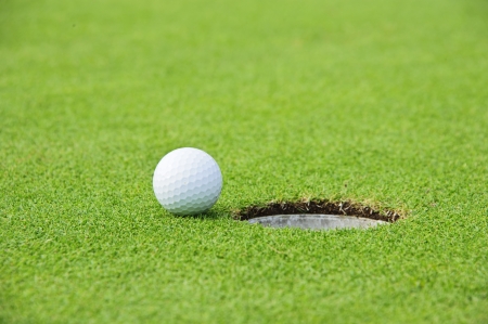 Golf Ball on Edge of Hole の写真素材