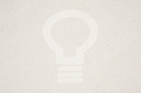 Bulb light icon on sand background and texturedの写真素材