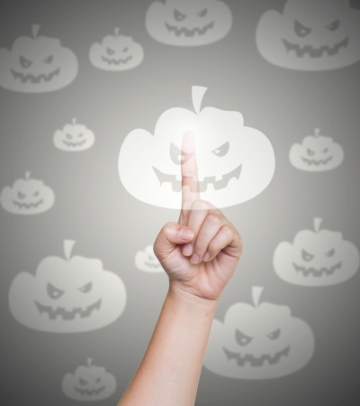 Hand pushing pumpkin button on a touch screenの写真素材