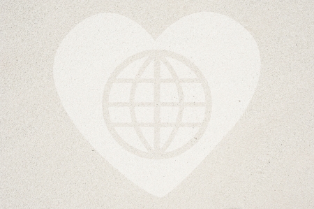Heart with global icon on sand background and textured の写真素材
