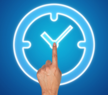 Hand pushing clock button on a touch screen interface の写真素材